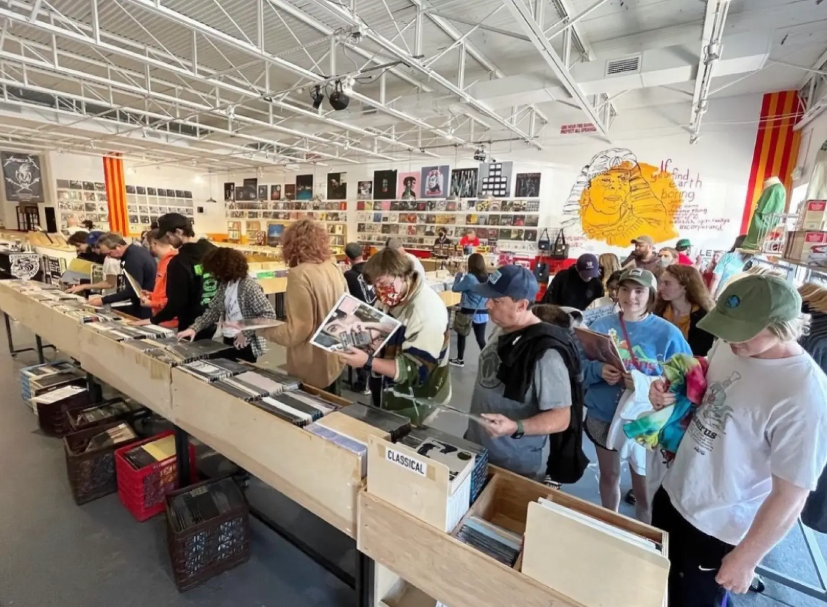 A large group of people browsing records at a record store.