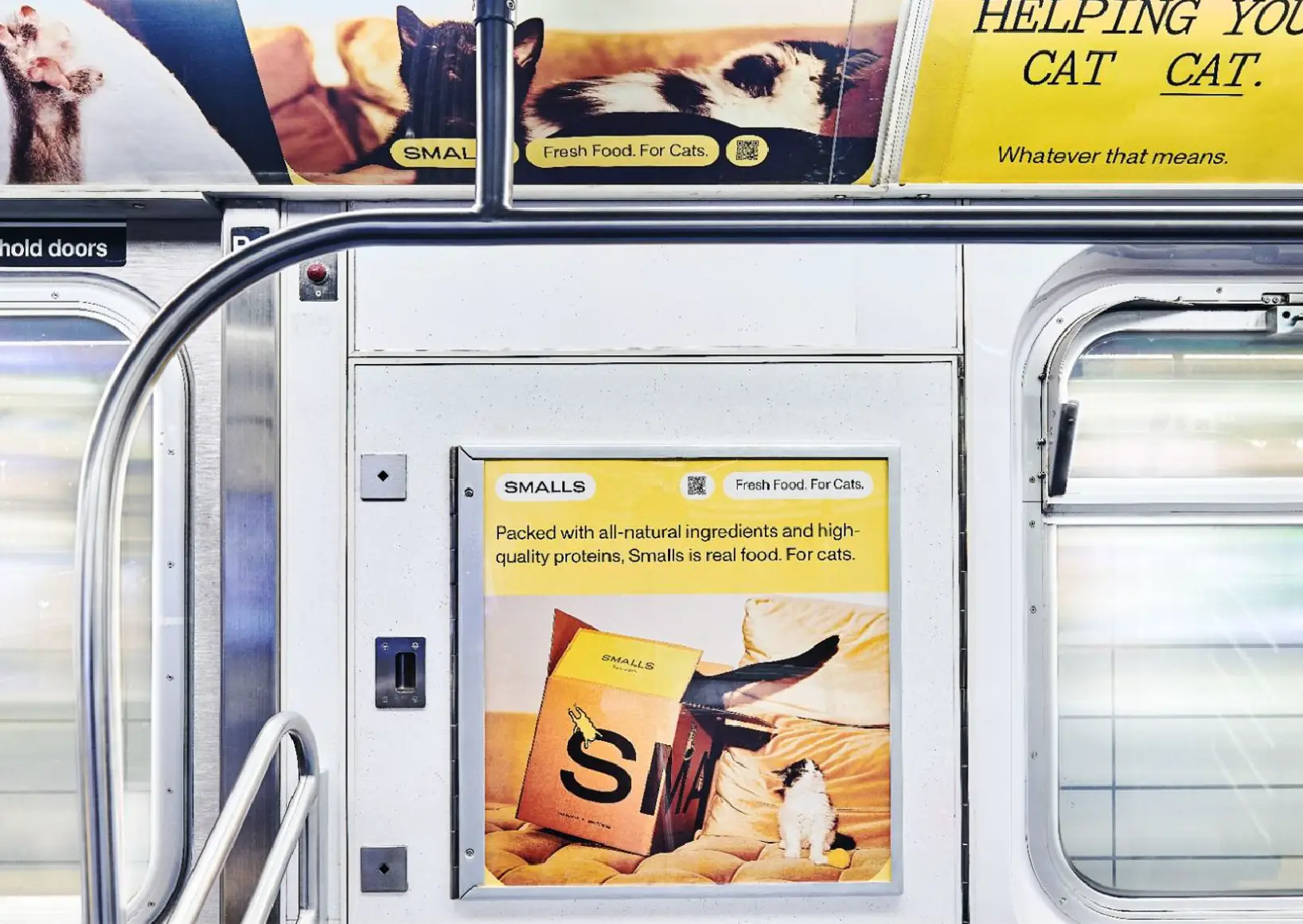 Photo within a New York City subway train showcasing Smalls advertising and QR Codes throughout.