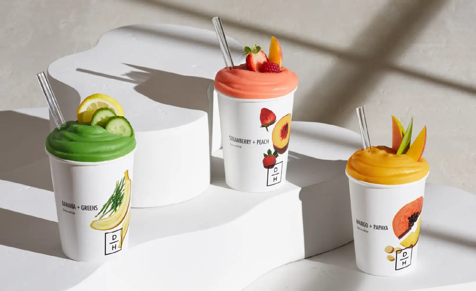 Three Daily Harvest smoothies set on a white table.