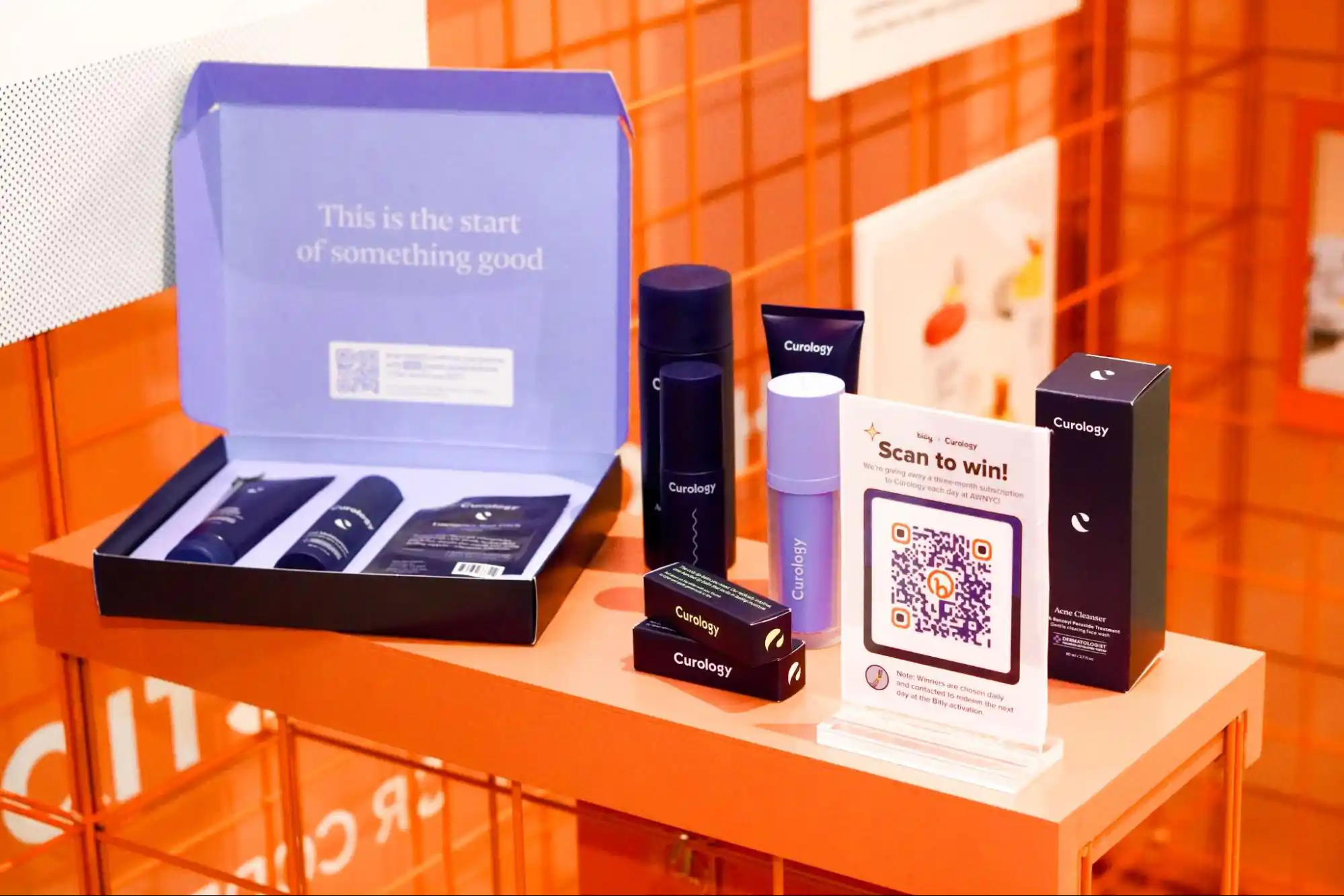 Display of Curology's skincare products at Bitly's booth at Advertising Week 2023 featuring a QR Code