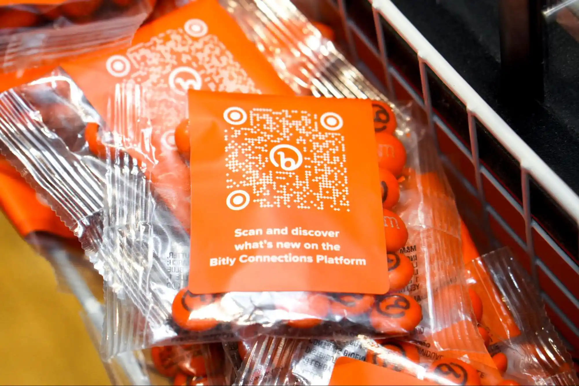 Bag of branded M&Ms at Bitly's booth at Advertising Week 2023 featuring a branded QR Code