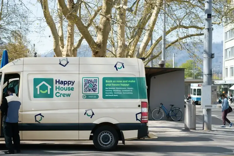 A man opening up the door of a van that has a turquoise, green, and white house logo and a QR Code