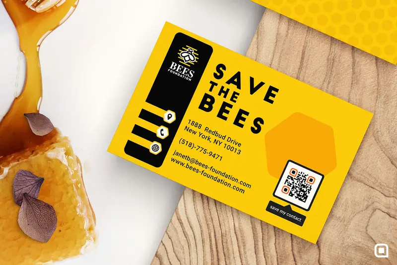 A yellow business card on a wooden board next to some honey.