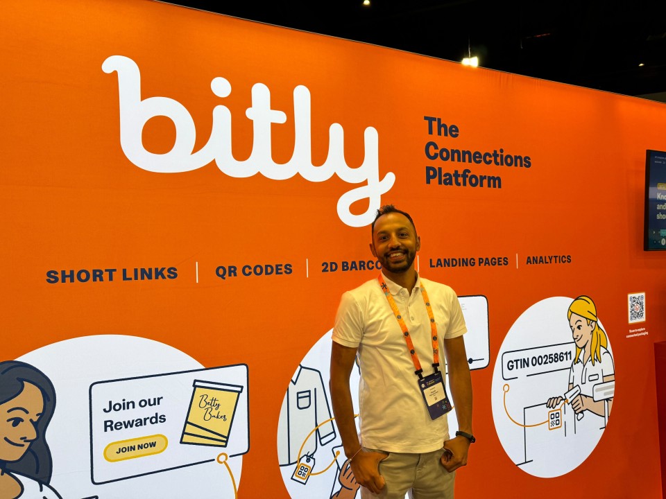 Photo of Ayub at the GS1 Connect event in front of the Bitly booth.